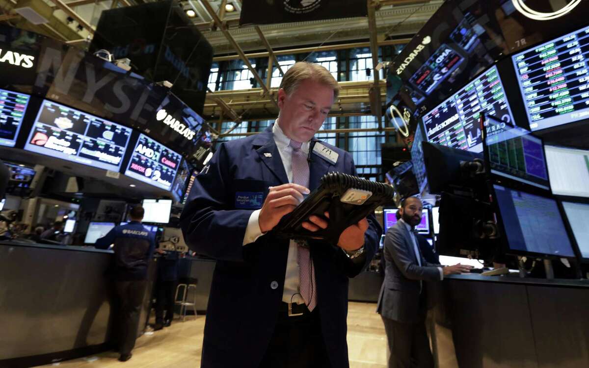 In this Sept. 18, 2013 file photo, Trader F. Hill Creekmore works on the floor of the New York Stock Exchange.