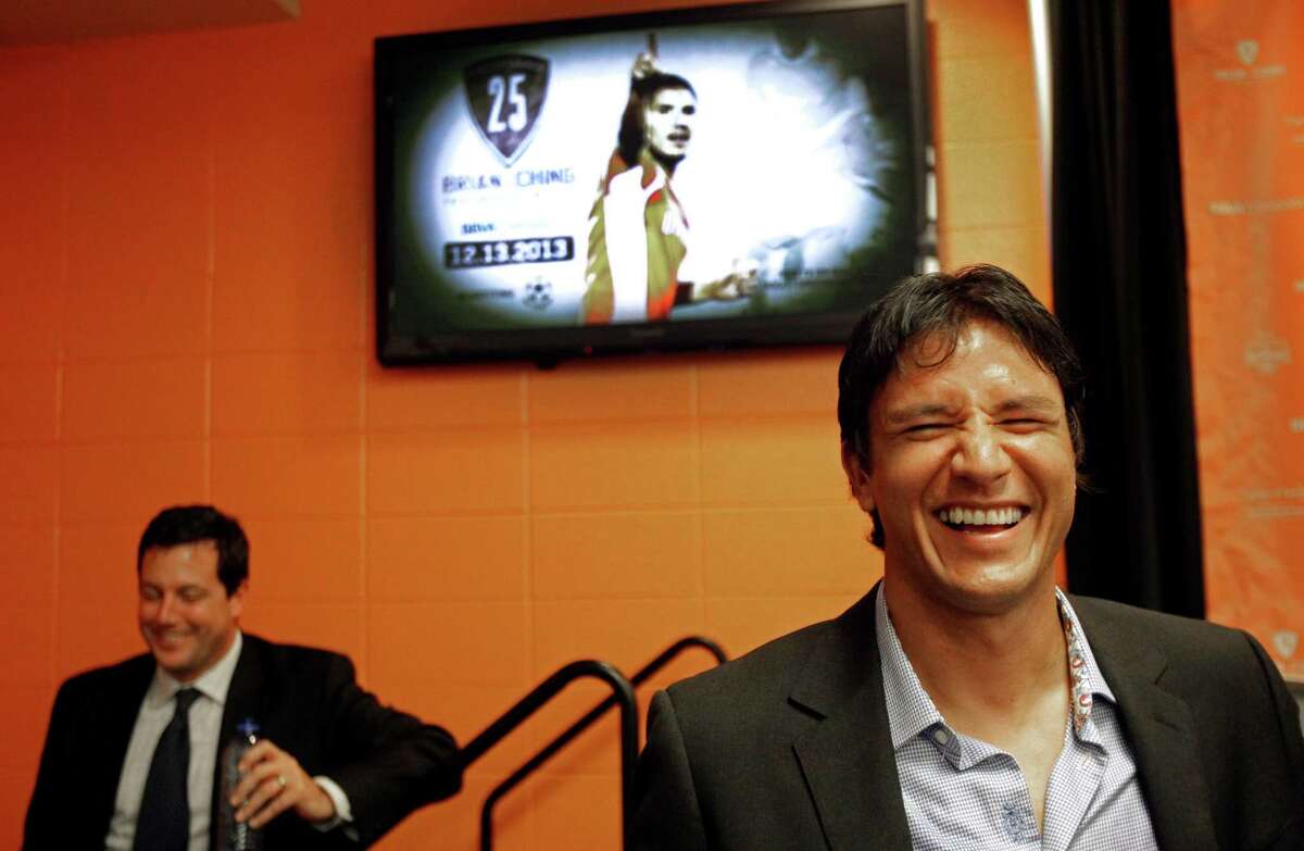 Houston Dynamo president Chris Canetti is shown left as Houston Dynamo forward Brian Ching, right, shares a laugh with members of the media after a media conference about his retirement held at BBVA Compass Stadium Tuesday, Sept. 24, 2013, in Houston. The Houston Dynamo and Dynamo Charities will host a Brian Ching Testimonial Match on Dec. 13. The event will benefit, The House That Ching Built, which is Ching's partnership with Houston Habitat for Humanity.