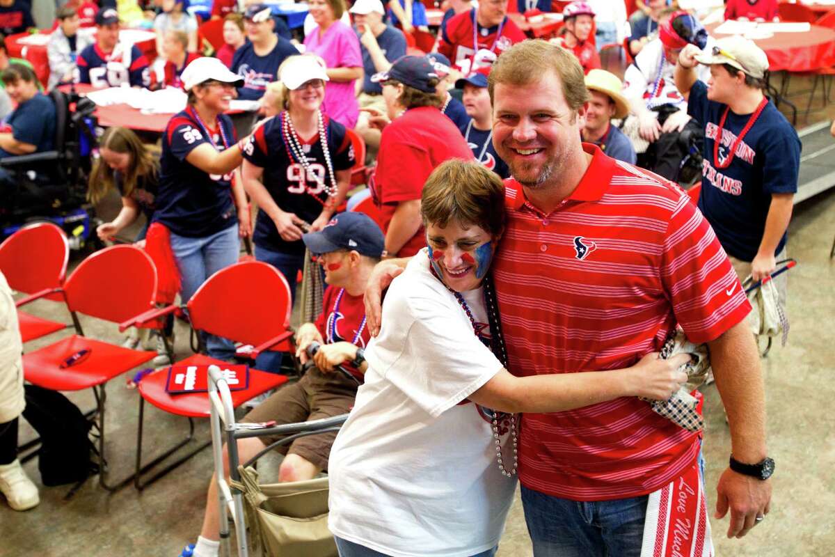 Houston Texans punter Shane Lechler embraces Brookwood Community citizen Michelle, during a visit by Lechler, kicker Randy Bullock and long snapper Jon Weeks Tuesday, Sept. 24, 2013, in Brookshire.