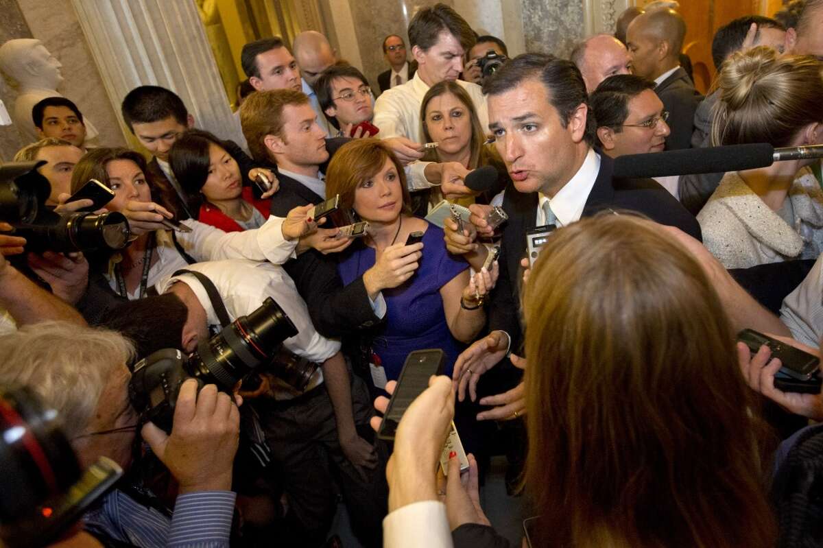 Sen. Ted Cruz, R-Texas, right, speaks to the media after leaving a marathon speech on the Senate floor on Capitol Hill in Washington, Wednesday, Sept. 25, 2013. Cruz ended the marathon Senate speech opposing President Barack Obama's health care law after talking for 21 hours, 19 minutes. (AP Photo/Jacquelyn Martin)