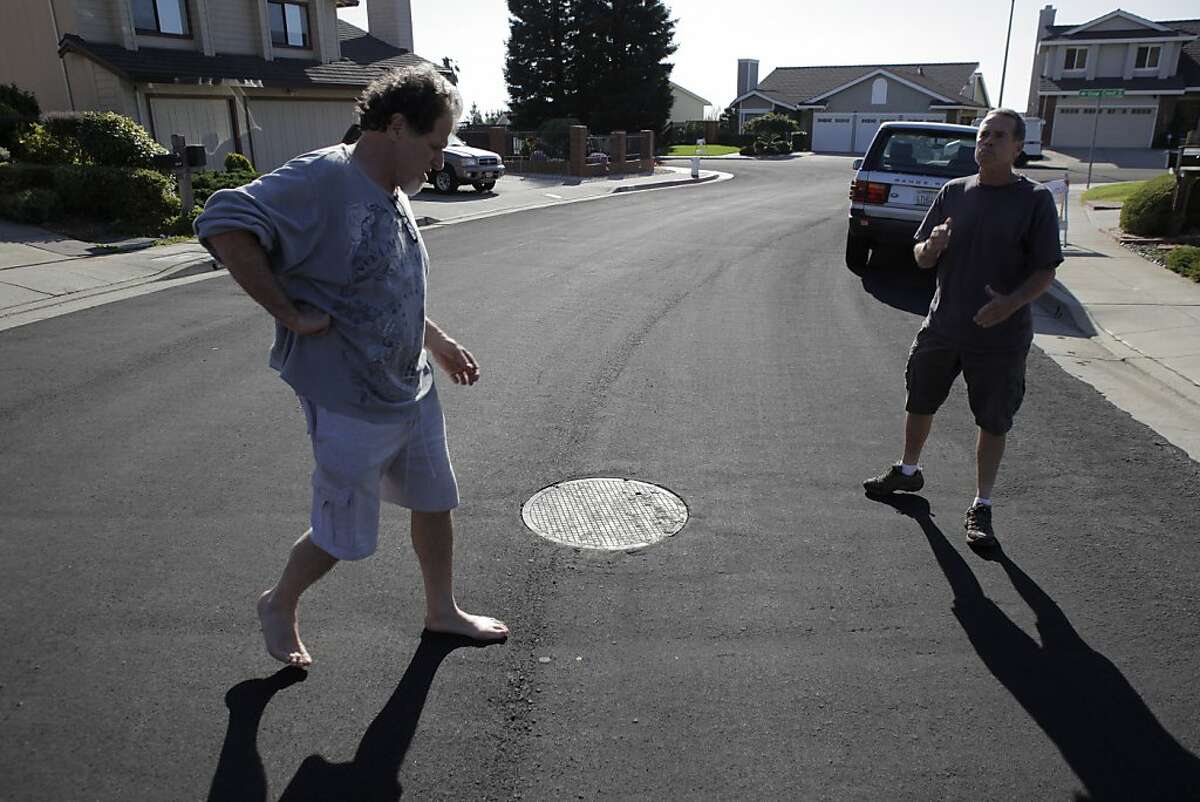 Steve Mendelson, left, and his neighbor, Bob Fitzgerald, right, who live on View Crest Court, talk about the bad street surface on Tuesday. Residents along Campus Drive in Oakland, Calif., are unhappy with the city's repaving of the street and intersecting streets on Tuesday, September 24, 2013. The complaints range from cracks not filled correctly to loose gravel and clumps of road surface coming loose.