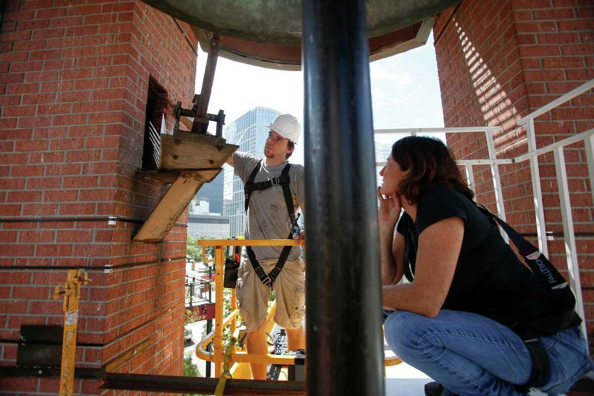 Troy Stanley, left, helps Houston artist Jo Ann Fleischhauer install a public art work in and around the clock tower at Market Square Sept. 23, 2013 in Houston. The work includes mirrors around the supports; a spiral staircase that will be used periodically by musicians for performances; and backlit images that become the backdrops for the clock faces. The work, called "What Time is It?" will be on display from Sept. 28 through March 29. (Eric Kayne/For the Chronicle)