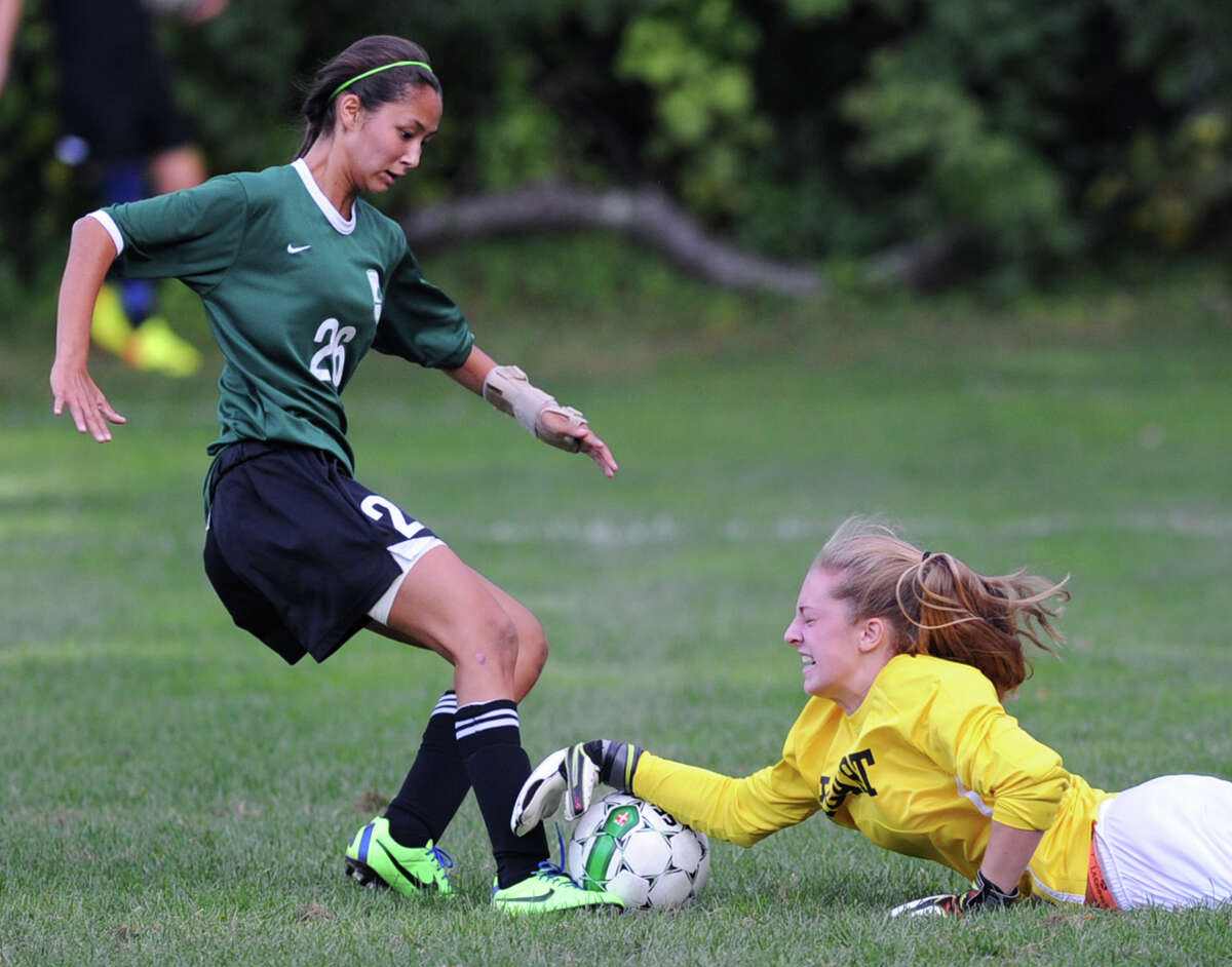 Convent of the Sacred Heart goalie Charlie Clark, right, dives to make the stop just before Greenwich Academy's Marguerite Basta (# 26) gets to the ball during the girls high school soccer match between Greenwich Academy and Convent of the Sacred Heart at Greenwich Academy, Sept. 25, 2013.