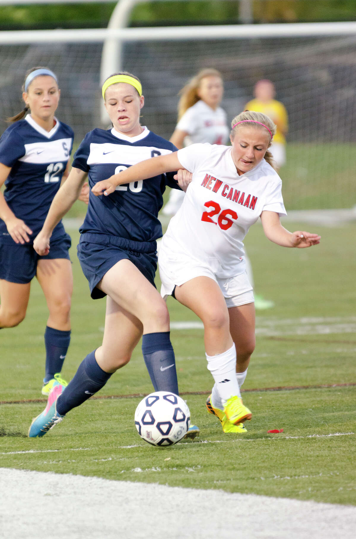 New Canaan's Courtney Overacker and Staples' Charlotte Rossi battle for control of the ball during the girls soccer game against Staples High School at New Canaan High School on Wednesday, Sept. 25, 2013.