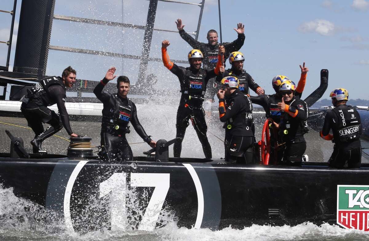 Oracle Team USA celebrates after winning Race 19 of the America's Cup Finals to take the America's Cup trophy on Wednesday, September 25, 2013 in San Francisco, Calif.