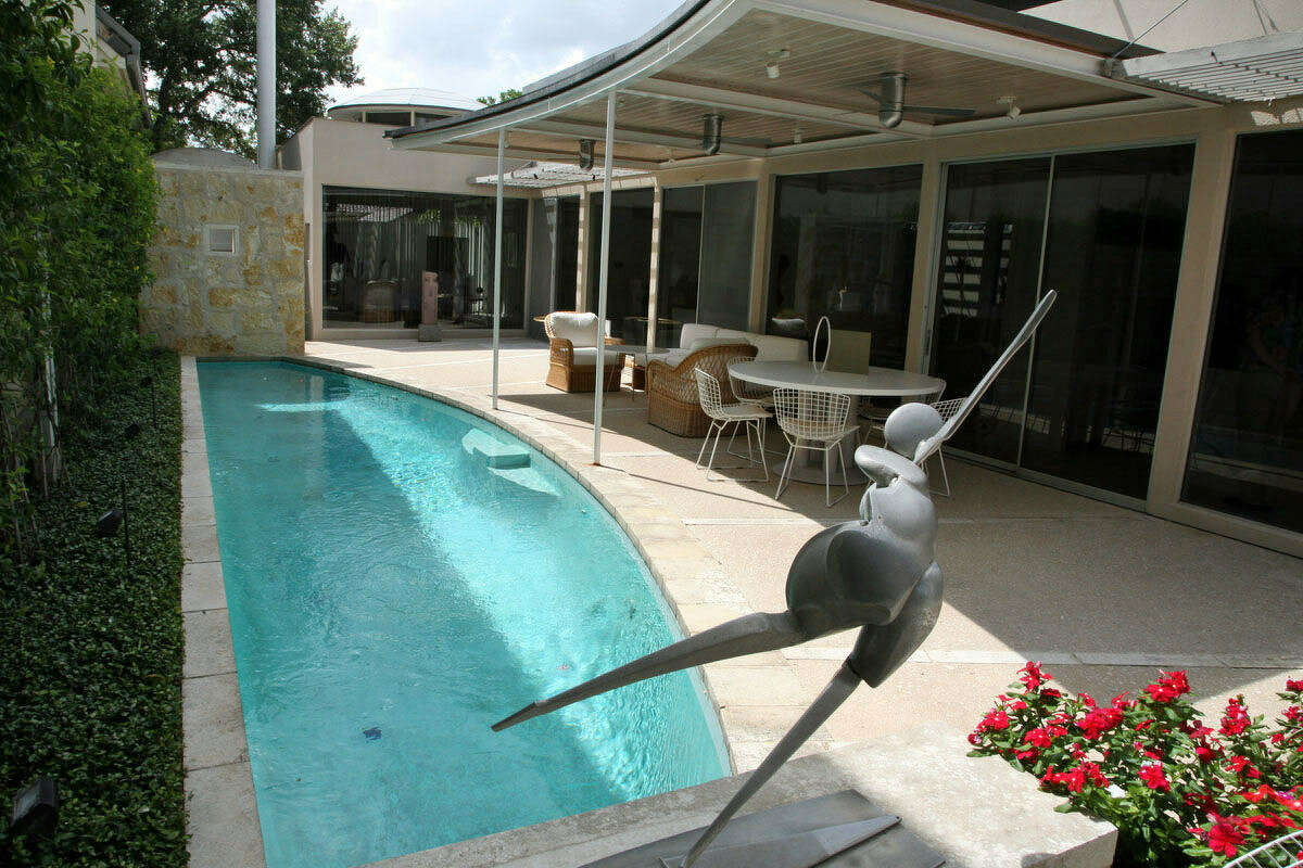 A metal sculpture by Evett appears ready to dive into the lap pool outside.