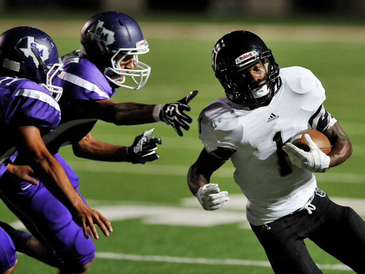 Steele wide receiver Jaylen Harris, right, evades San Marcos defenders and runs for a touchdown during a high school football game, Thursday, Sept. 26, 2013, at Bobcat Stadium in San Marcos, Texas.