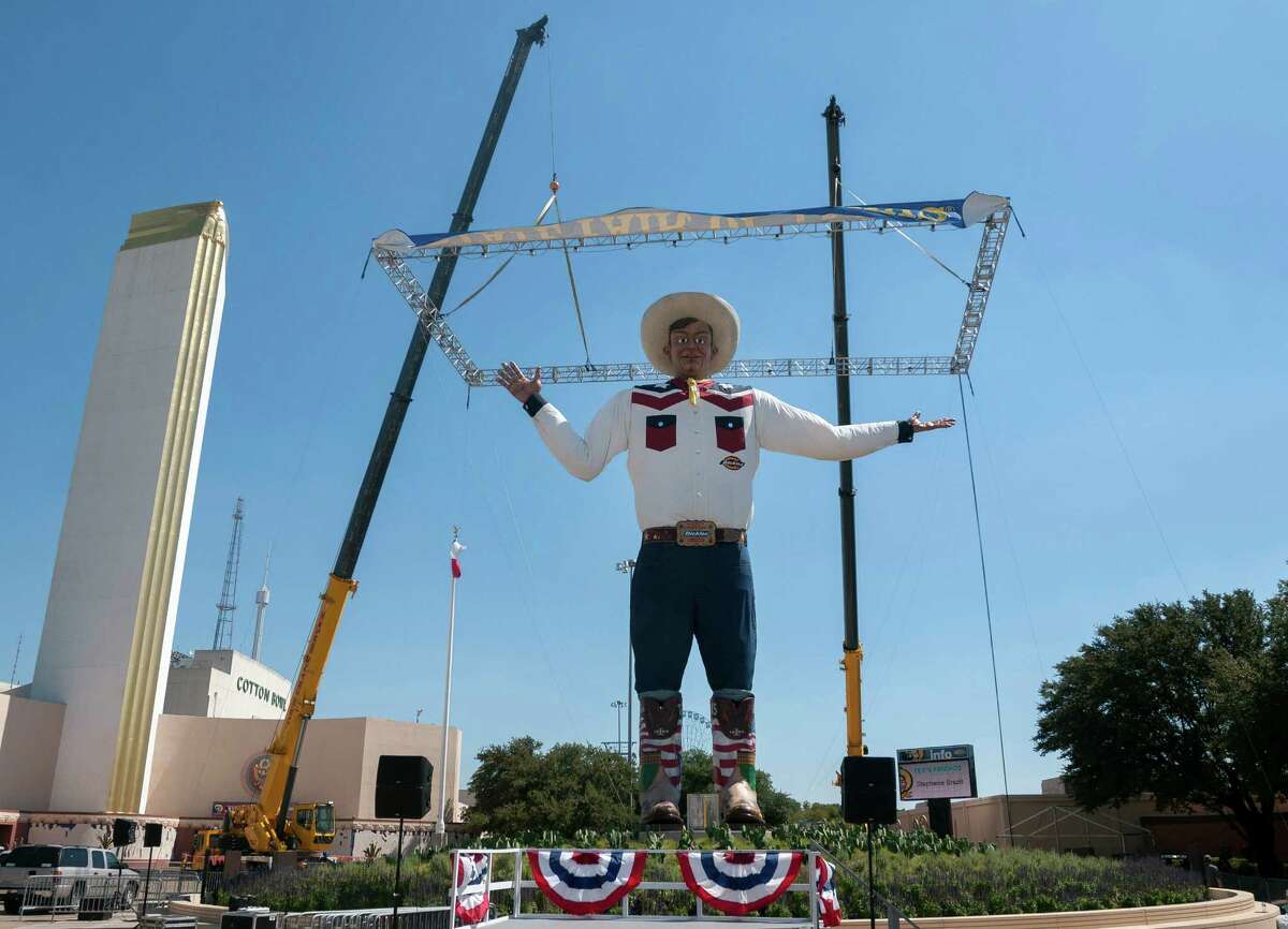 Big Tex, the 55-foot-tall symbol of the State Fair of Texas, is unveiled Thursday, Sept. 26, 2013, one day earlier than scheduled, in Dallas. Big Tex was supposed to be revealed Friday, before television news helicopters caught a glimpse of the head surrounded on four sides by draping. He was rebuilt for this year after going up in flames in the closing days of the fair last year.