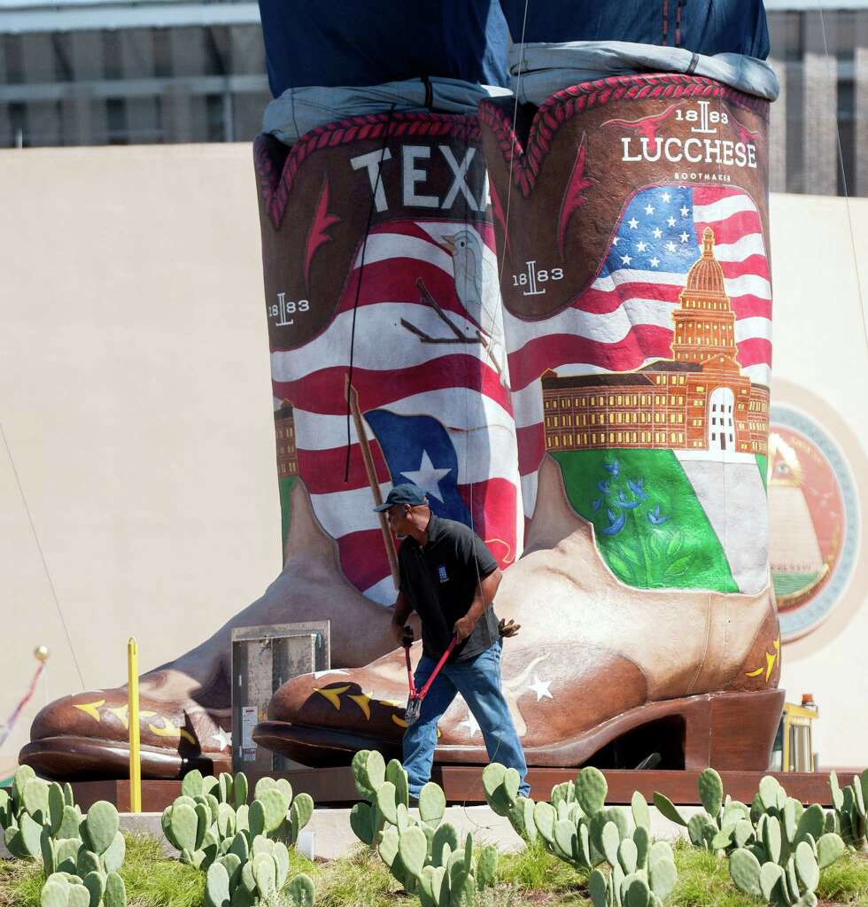 A Worker Walks Near The Boots Of Big Tex 55 Foot Tall A Worker Walks Near The Boots Of Big Tex 55 Foot Tall