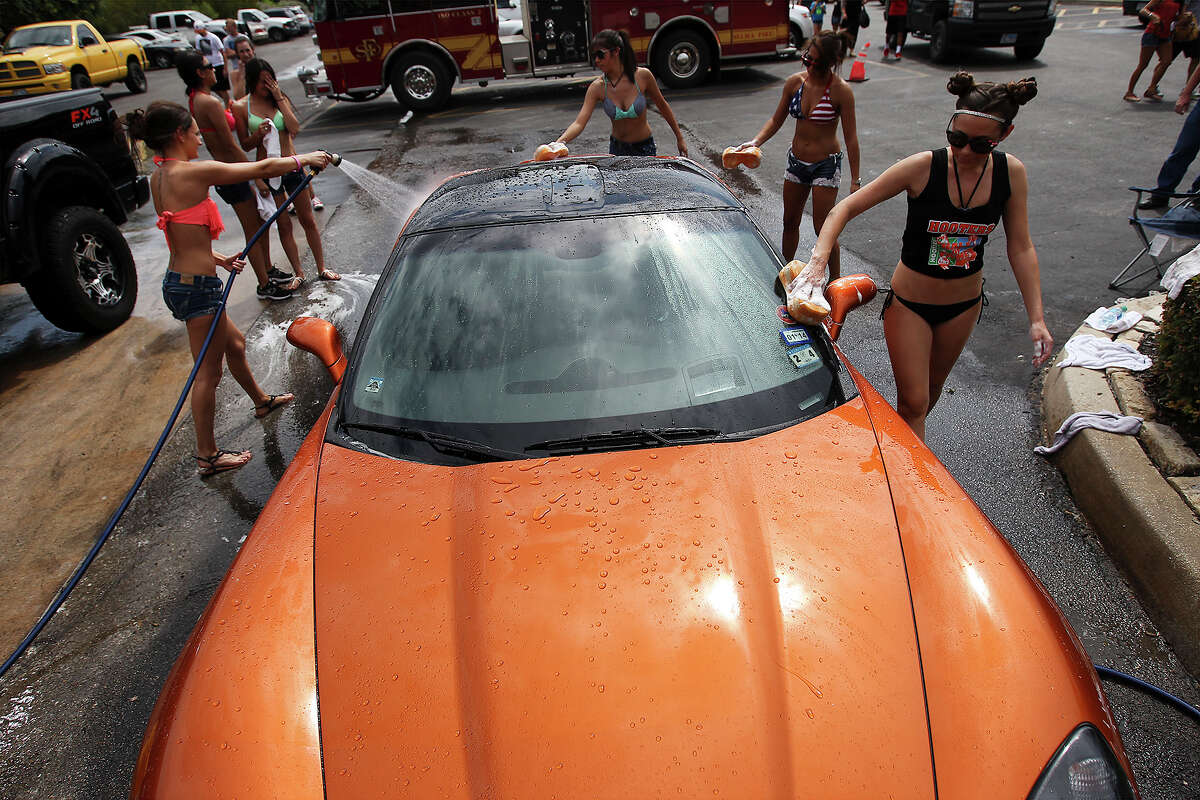 Hooters employees wash a 2008 Chevrolet Corvette at a charity car wash for donations to help two Selma police officers, Tiffany Kierum and Jesus Balderamas, who both were shot and wounded while responding to a family violence call earlier in the month. The Hooters restaurant located in Selma held the car wash on Saturday, Sept. 28, 2013. Manager Joe Cossio said Kierum worked at Hooter's for about six years before she became a police officer. "I couldn't ask fo an employer like she was. She was great," Cossio said. The donations from an earlier bake sale and the car wash will be matched by the corporation according to Cossio. Approaching the afternoon, over 20 vehicles had already been washed and dried at the charity event.