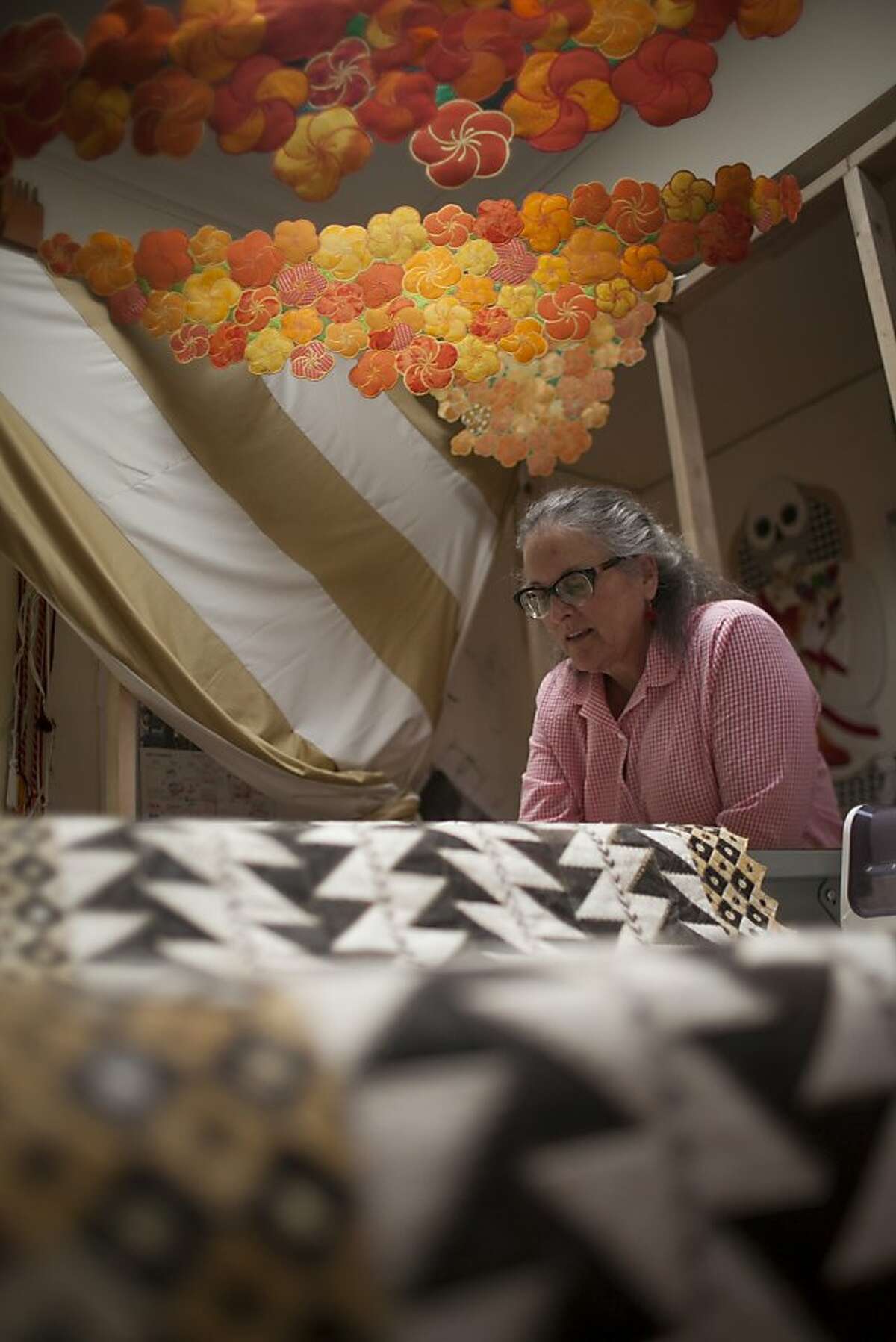 Artist Wendeanne Stitt, in her home in Santa Cruz, surrounded by quilts she produced for an upcoming exhibit in Oakland on September 24th 2013.