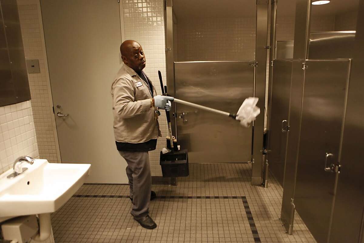 Custodian Richard Mathews clear debris left behind by visitors to the men's restroom at San Francisco's main library on Tuesday Oct. 1, 2013, in San Francisco, Calif. The bathrooms become so dirty a custodian cleans up every twenty minutes throughout the day.