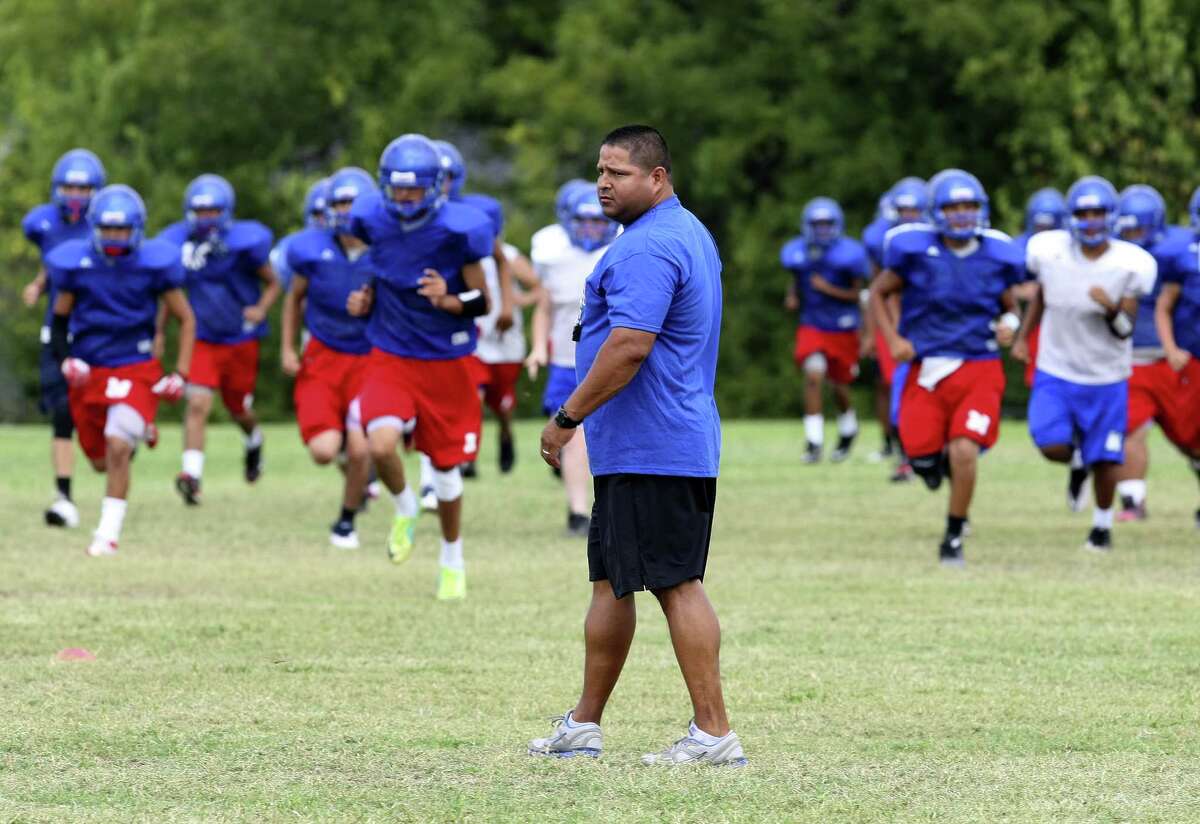 Memorial High School Head Coach Alex Guerra works with the team during practice on Thursday Sept. 5, 2013.