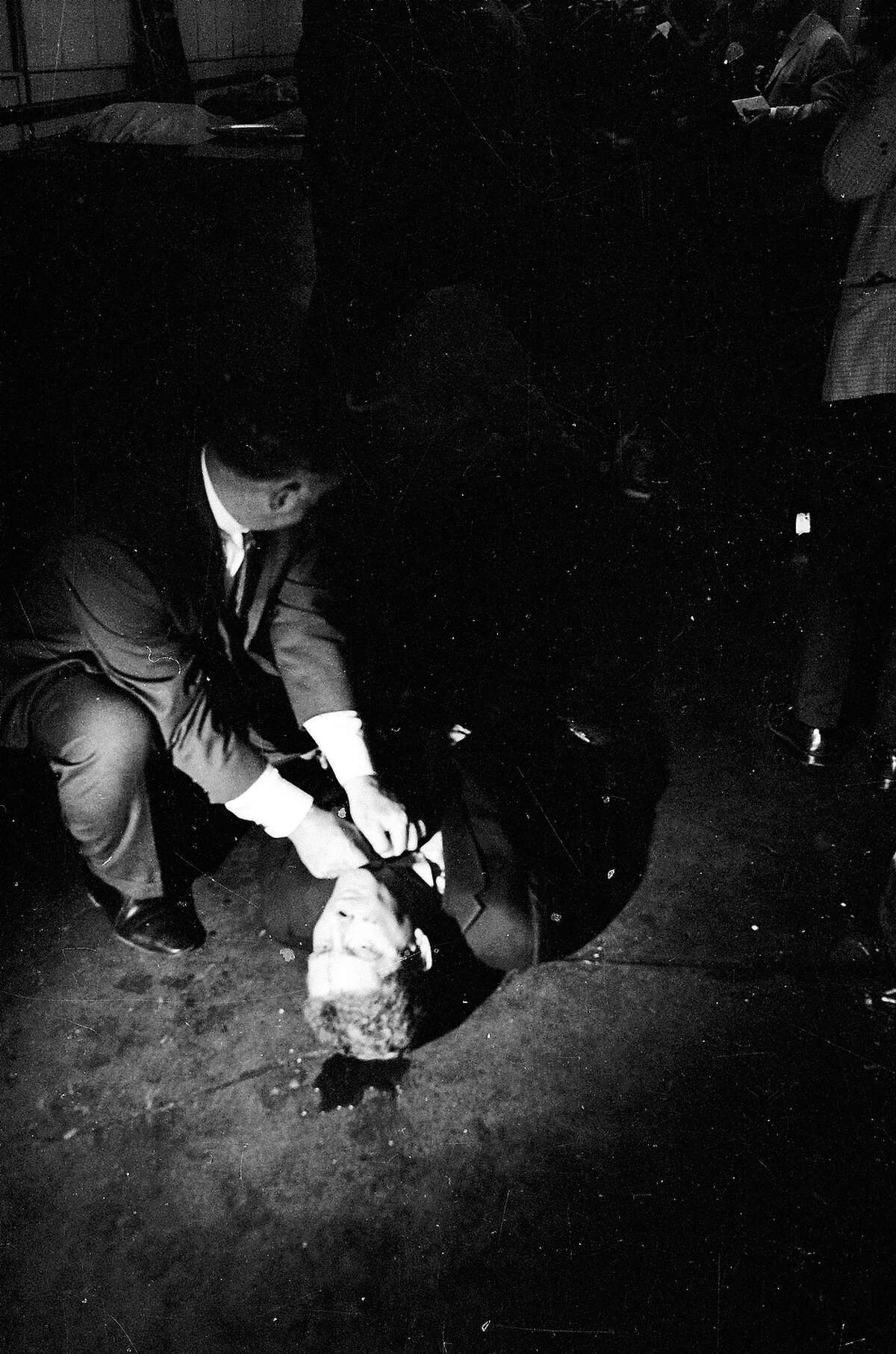 A man aids Senator Robert F. Kennedy who is laying on the kitchen floor of the Ambassador Hotel moments after being fatally shot by assassin Sirhan Sirhan.