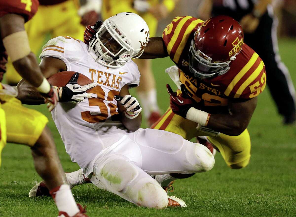 Texas running back Johnathan Gray is tackled by Iowa State linebacker Jeremiah George, right, during the second half of an NCAA college football game on Thursday, Oct. 3, 2013, in Ames, Iowa. Texas won 31-30.