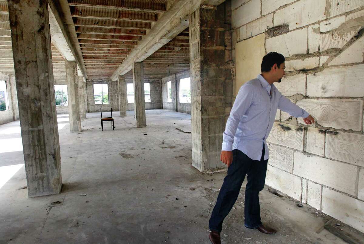 Apurva Sanghavi touches an original portion of the former Schlumberger building at the corner or Leeland and Delano Streets, Wednesday, Oct. 2, 2013, in Houston. Gaurav Khandelwal and Apurva Sanghavi plan to redevelop the building in the East End. (Cody Duty / Houston Chronicle)