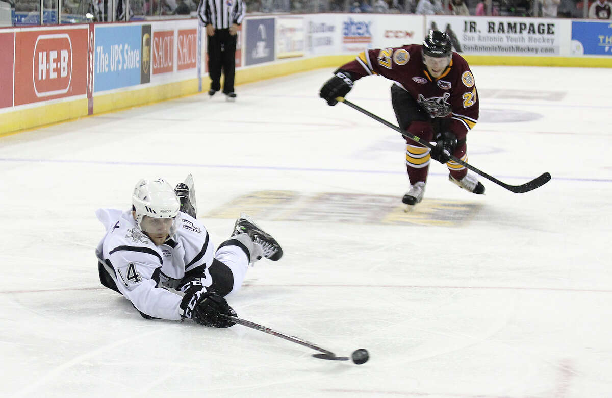 Rampage's Vincent Trocheck (14) dives to attempts a shot at the goal against Chicago Wolves' Pat Cannone (21) during the Rampage's home opener on Friday, Oct. 4, 2013.