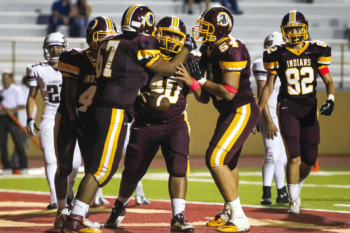 Harlandale's Juan Moncivaiz (center) rejoices with Zachary Borrego (right) and Edmundo Maldonado after his 7-yard TD reception in the fourth quarter, giving the Indians their final victory margin vs. Floresville.