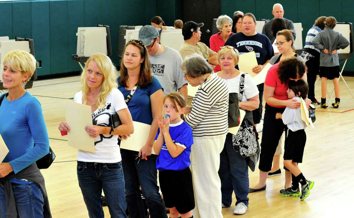 Newtown residents vote on a referendum accepting $49.25 million from the state to demolish the current Sandy Hook Elementry School and build a new one. Voting is seen here at Newtown Middle School in Conn. Saturday, Oct. 5, 2013.