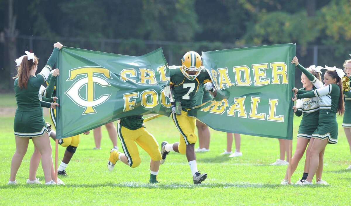 Neno Merritt (# 7) of Trinity Catholic leads his team onto the field during the high school football game between Greenwich High School and Trinity Catholic High School at Trinity in Stamford, Saturday, Oct. 5, 2013. Greenwich won the game over Trinity Catholic, 42-14.