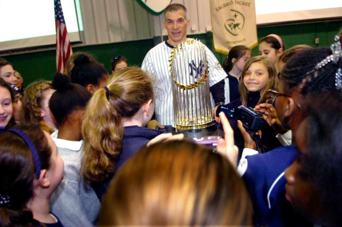 New York Yankees' manager, Joe Girardi, with his daughter, Serena Girardi, right, and the students of Convent of the Sacred Heart, admire the 2009 World Series campionship trophy, on January 26, 2010 at the school's celebration for the Yankees.
