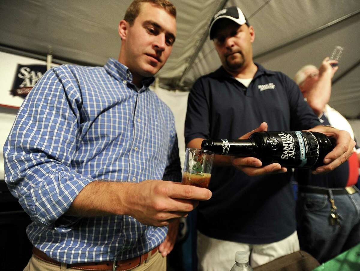 Nathan Staggs of Giglio Distribution Co. pours a beer with Sam Adams representative Matt Ludlow at the Art of Beer held at the Art Museum of Southeast Texas on Thursday, October 4, 2012. Photo taken: Randy Edwards/The Enterprise