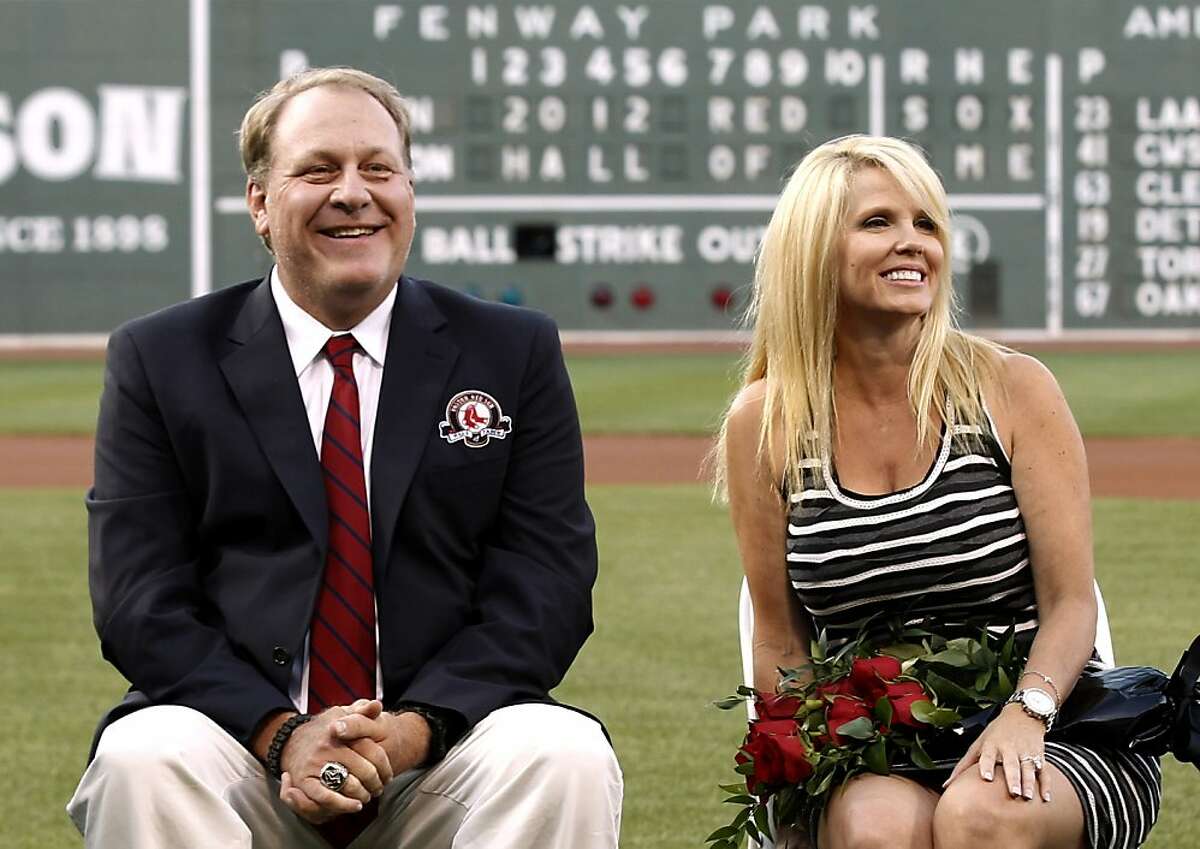 FILE - In this Aug. 3, 2012 file photo, former Boston Red Sox pitcher Curt Schilling sits with his wife Shonda, right, after being introduced as a new member of the Red Sox Hall of Fame before a baseball game between the Red Sox and the Minnesota Twins at Fenway Park in Boston. Schilling, whose video game company collapsed into bankruptcy, is selling off furniture, sports collectibles and even artificial plants from his Massachusetts home. An estate sale company has scheduled a sale of items from Schilling's seven-bedroom, 8,000-square-foot Medfield residence for Saturday, Oct. 12, 2013. (AP Photo/Winslow Townson, File)