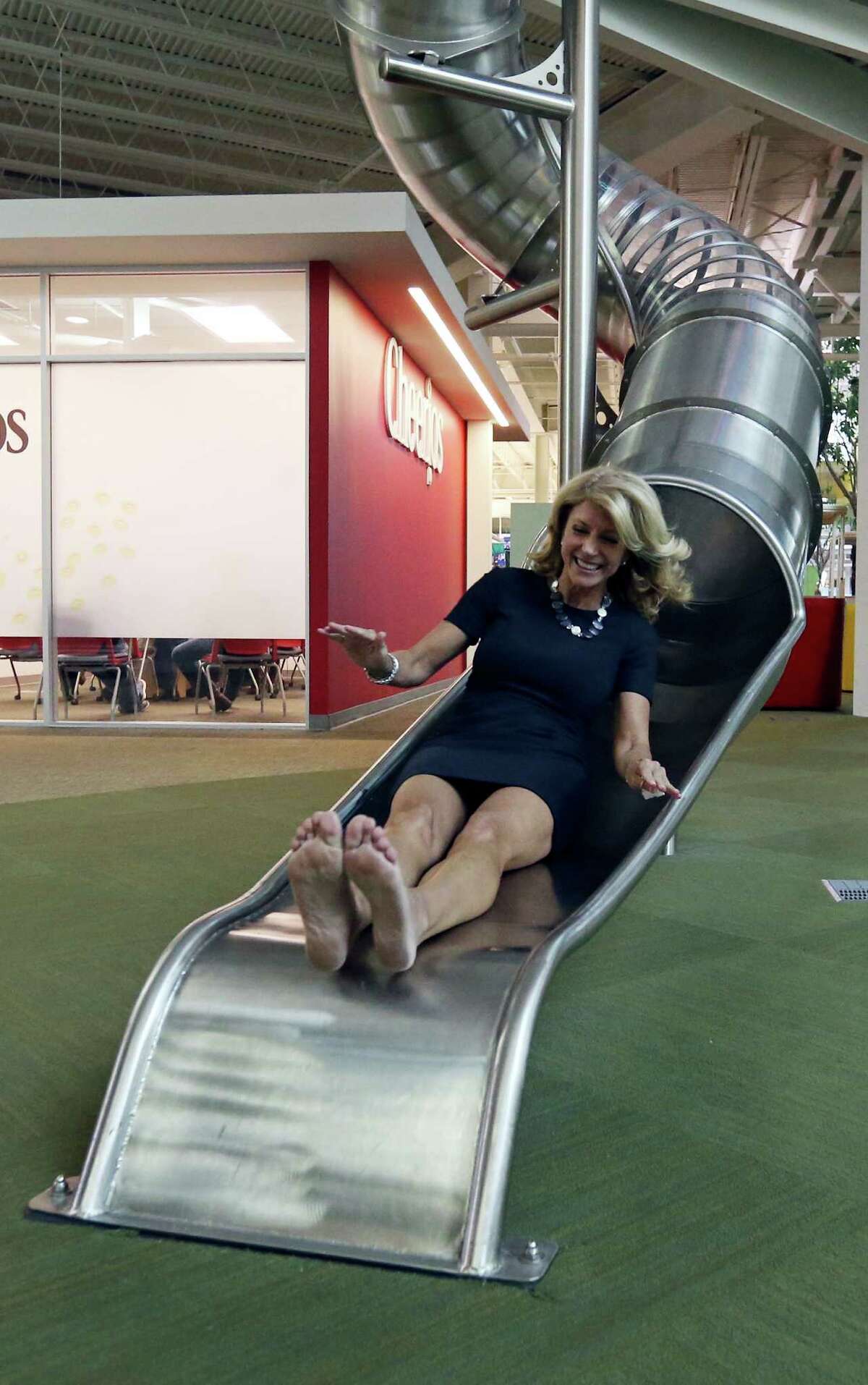 State Senator Wendy Davis, who is running for Texas Governor, takes the slide on a tour of Rackspace Hosting Inc. Monday Oct. 7, 2013.