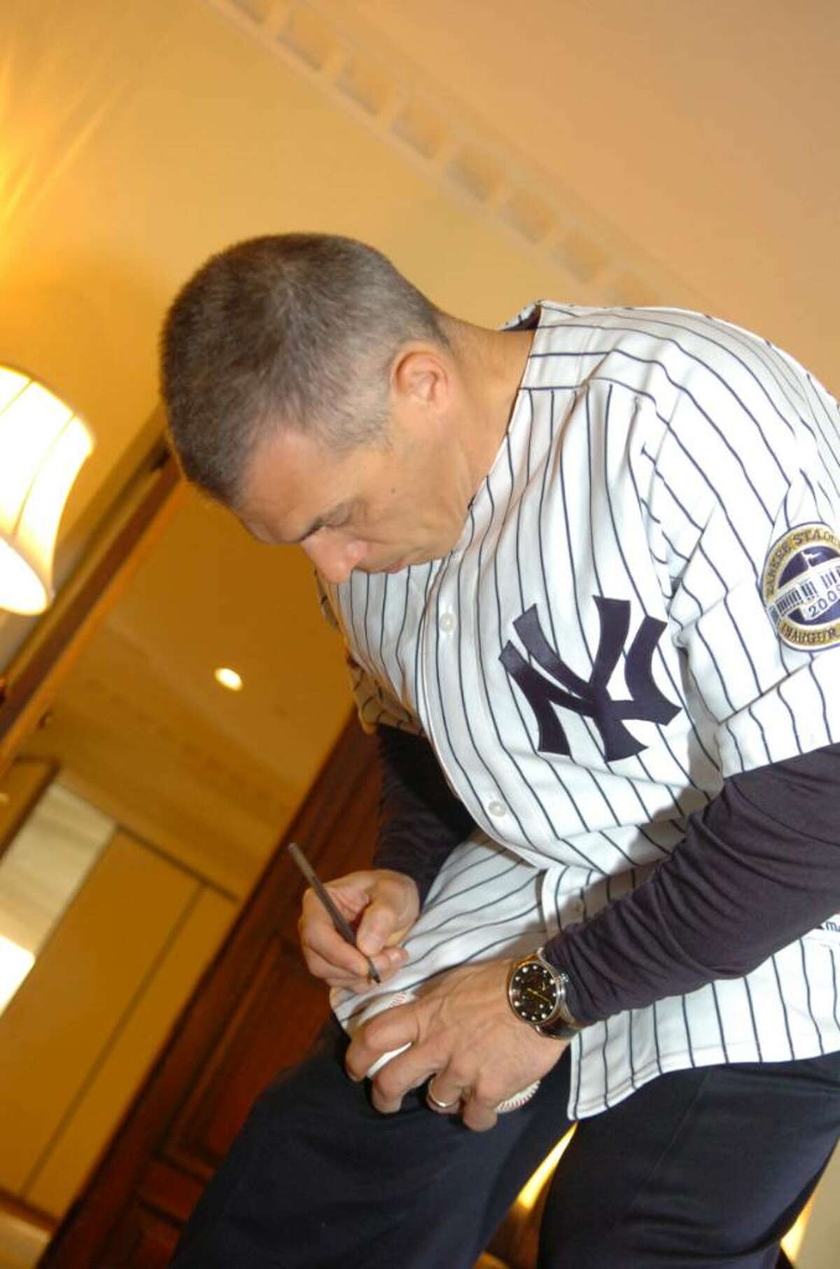 New York Yankees manager Joe Girardi autographs baseballs at the Convent of the Sacred Heart's celebration of the Yankees 2009 World Series championship on January 26, 2010.