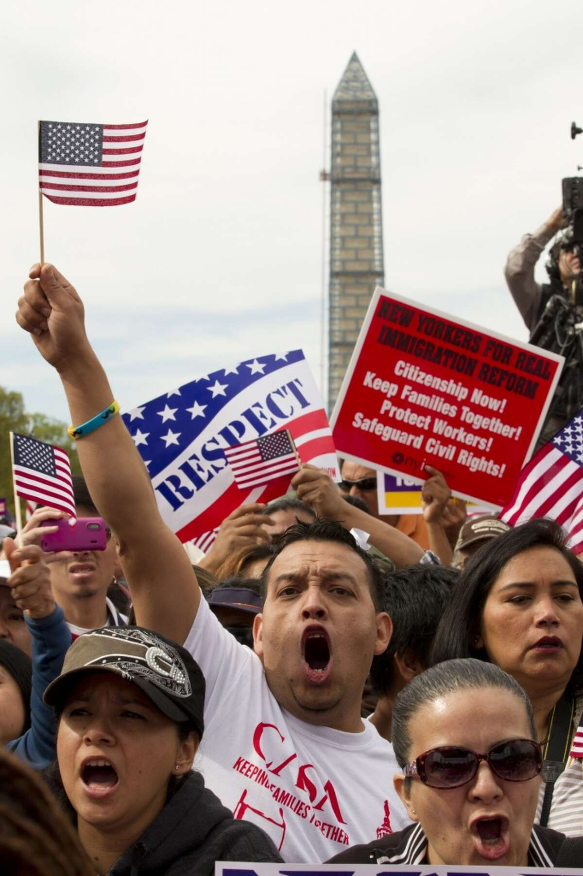 Demonstrators shout during a immigration a rally on the National Mall in Washington, Tuesday, Oct. 8, 2013, calling on the House Republican leadership to pass comprehensive immigration reform with a path to citizenship. The Washington Monument is in the background. ( AP Photo/Jose Luis Magana)