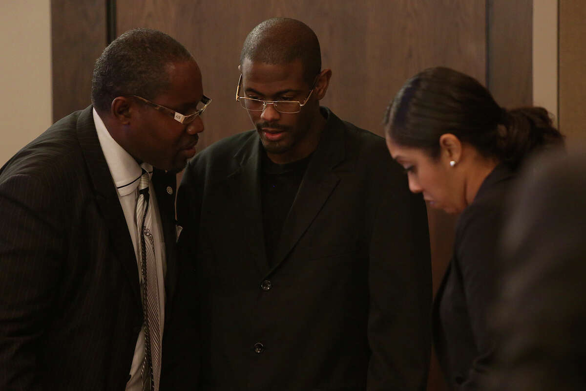 Bernard "B.J." Brown, center, confers with his attorneys Cleophus Marshall, left, and Jennifer Maritza Perez-Stewart, right, during his trial for the murder of Samuel Johnson, Jr. in the 379th District Court in San Antonio on Tuesday, Oct. 8, 2013.