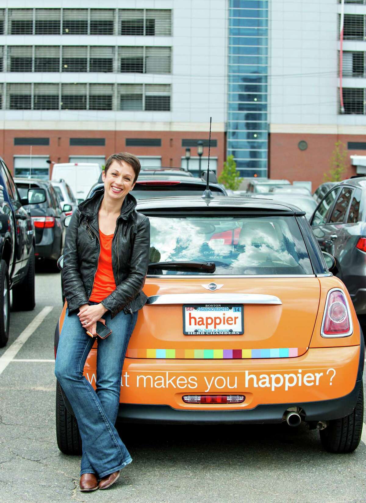 If Facebook's official color is blue, Happier's is orange. Nataly Kogan, the creator of the Happier app and website, drives an orange Mini Cooper to promote her social network.