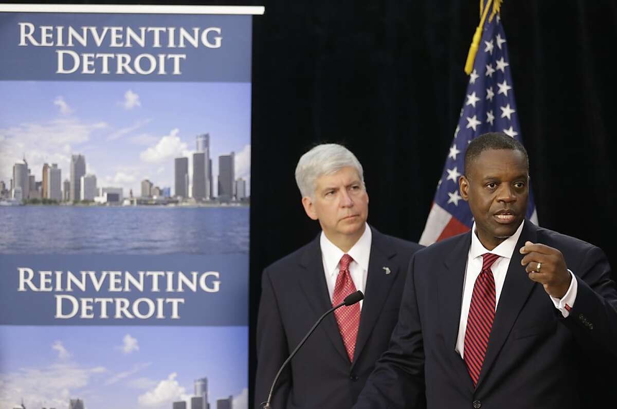 FILE - In this July 19, 2013, file photo, state-appointed emergency manager Kevyn Orr, right, and Michigan Gov. Rick Snyder, address reporters during a news conference in Detroit after Orr asked a federal judge for bankruptcy protection. While no other city is expected to join Detroit in bankruptcy court anytime soon, Detroit's bankruptcy is casting a shadow over a long list of cities across the U.S. and giving mayors new urgency in the search for solutions to the greatest challenge to face America's cities in a generation. (AP Photo/Carlos Osorio, File)
