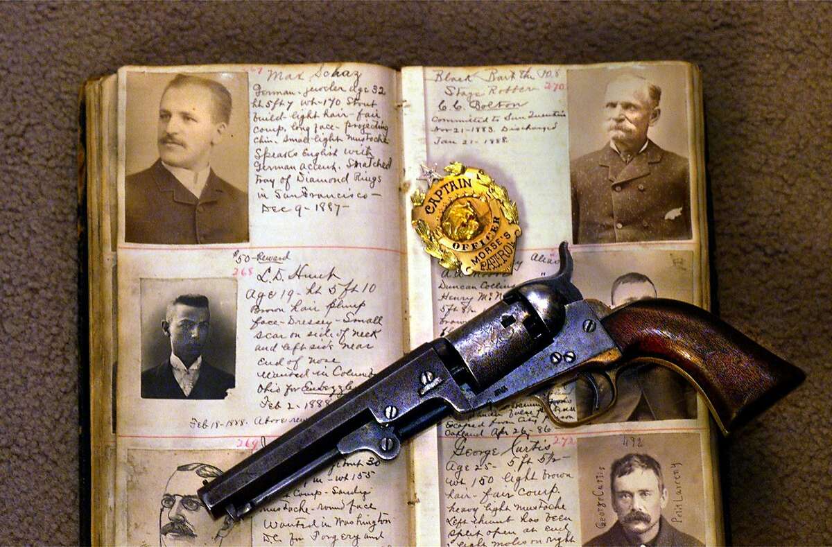 WORKMAN18-C-15NOV99-PZ-VM John Boessenecker Foster City lawer just came out with his 5th book California Wild West history he is also a collector of wild west guns and memorabilia. A San Jose mug book with a photo of Black Bart stage robber top right ,Colt revolver and badge Harry Morse captor of Black Bart in 1883 by Vince Maggiora