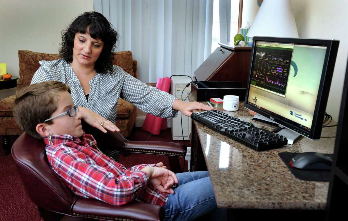 Roseann Capanna-Hodge, and educational psychologist consultant neurofeedback practitioner, works with Drew Cousens, 10, of Bethel, Friday, Oct. 11, 2013 in her Ridgefield, Conn. office.