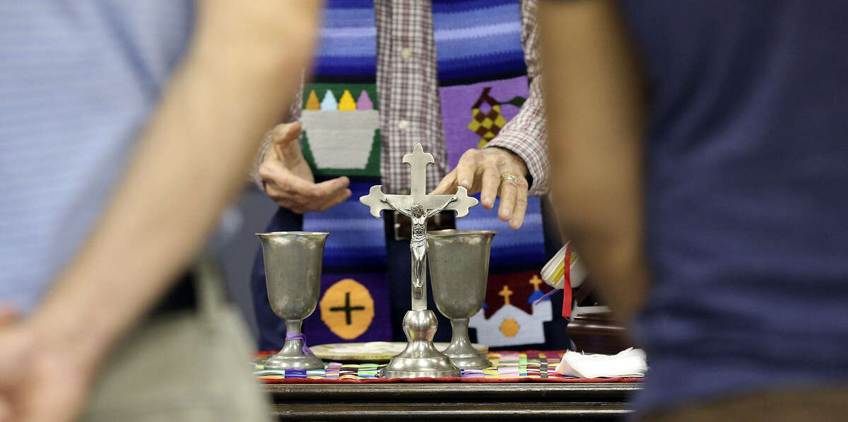 A table holding a crucifix and candles serves as the altar during the Dignity service.
