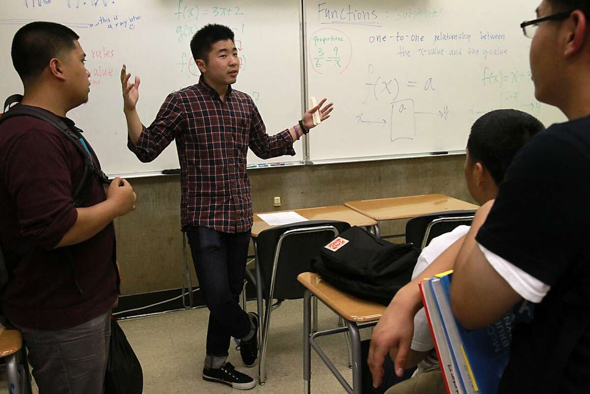 Math teacher Andrew Kim, 23, center, talks to students about details on the new free, weekly SAT math prep class held after school that they just took, from left, Joey Lumagbas, 17, Joey Saephan, 17, and Raul Vicuna III, 17, at Richmond High School October 8, 2013 in Richmond, Calif. The school started offering free SAT prep courses this year for anyone who wants to attend.