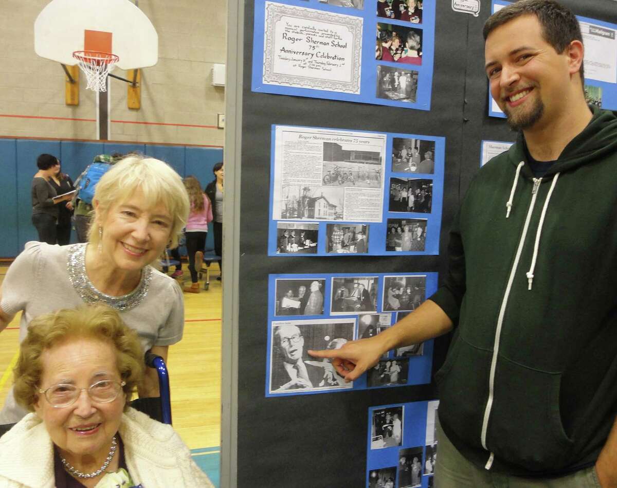 At the 100th anniversary reception at Roger Sherman Elementary School on Friday night, hundreds of alums, former teachers and at least one former principal joined the celebration. Among those attending was the family of Walter Holt, who served as principal from 1963 to 1973. Pictured here, from left to right, are his daughter Sharon Cloutier of Trumbull, widow Ruby Holt of Fairfield and grandson Nicolas Cloutier of Bristol, as they look at a photo of Walter Holt on a display board. FAIRFIELD CITIZEN, CT 10/11/13