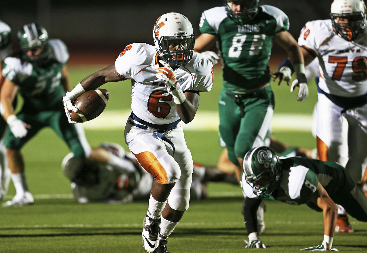 Maverick running back Dominique Daniels blasts through a hole on the rignt to score in the first half as Madison plays Reagan at Heroes Stadium on October 10, 2014.