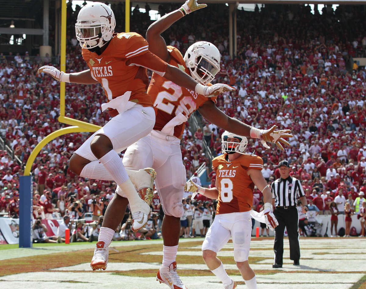 Texas Longhorns' Mike Davis (from left), Malcolm Brown, and Jaxon Shipley celebrate after Davis scored a touchdown on a pass play against the Oklahoma Sooners during second half action of the Red River Rivalry held Saturday Oct. 12, 2013 at Cotton Bowl Stadium in Dallas, Tx. The Longhorns won 36-20.