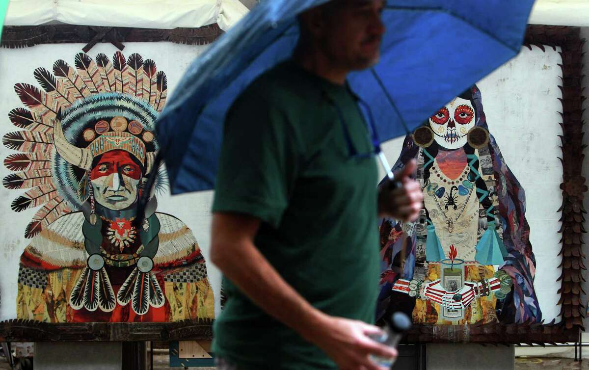 Mixed media pieces by artist Dolan Geiman stay safe despite rain during the last day of the Bayou City Arts Festival on Sunday, Oct. 13, 2013, in Houston.