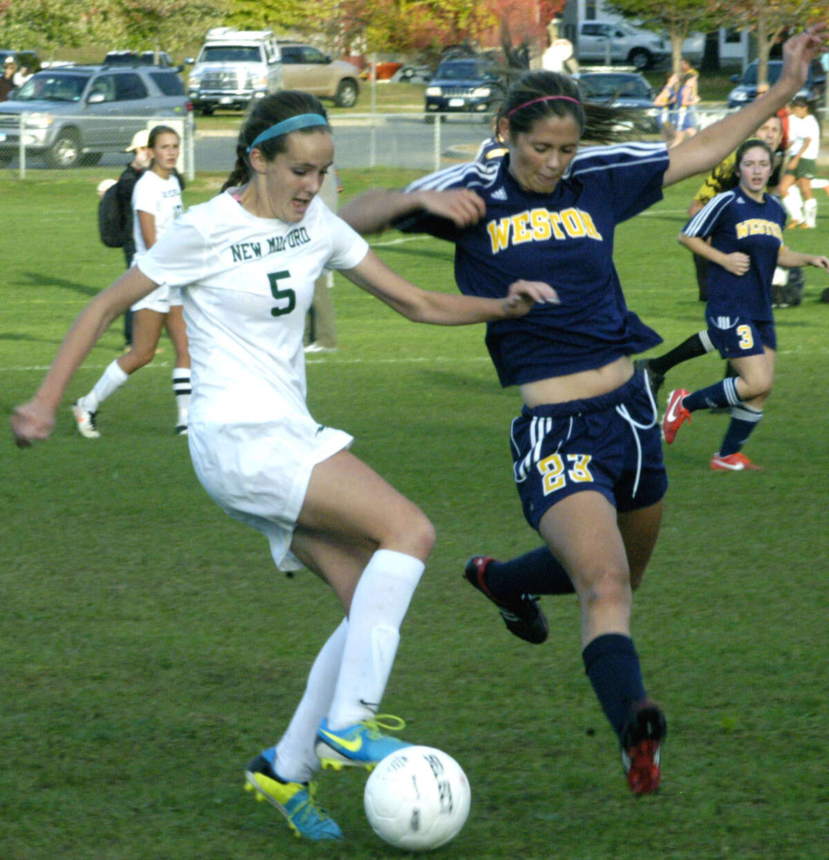 The Green Wave's Rachel Weir slams on the breaks to avoid Trojan defensive efforts during New Milford High School girls' soccer's 1-0 defeat to visiting Weston, Oct. 8, 2013.
