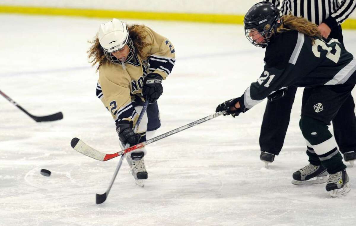 Notre Dame-Fairfield's Molly Verderame and Guilford's Megan Powell battle for the puck during Wednesday night's game at the Milford Ice Pavilion.