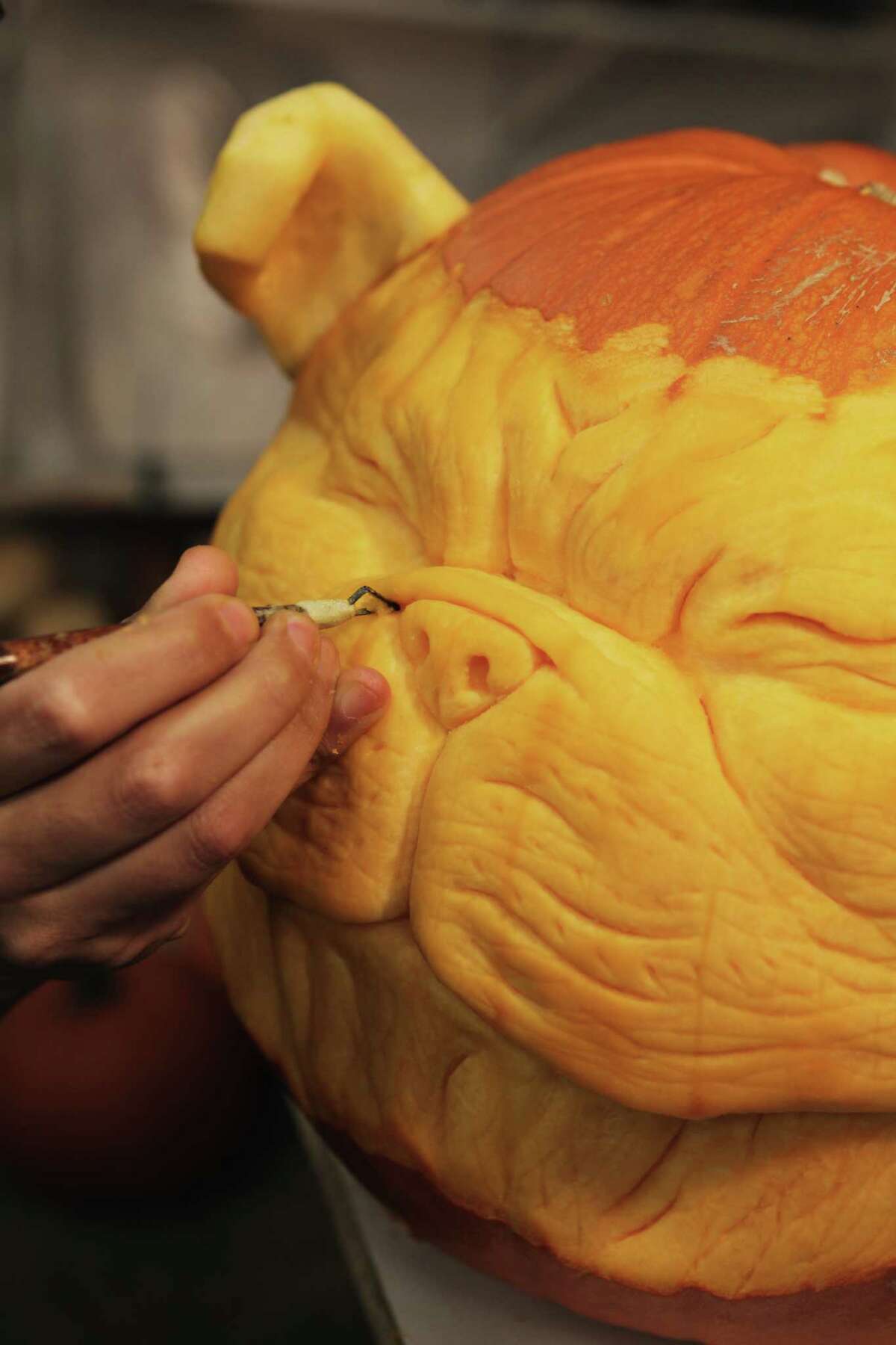 Alfred Paredes puts the finishing touches on a 3D pumpkin sculpture for Halloween.