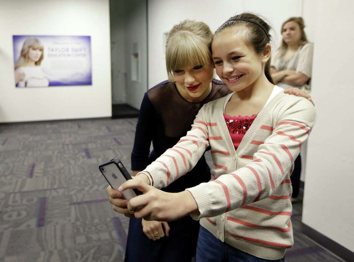 Taylor Swift poses for a photo with Piper Moralez, 11, at the Country Music Hall of Fame and Museum in Nashville, Tenn. Swift is at the facility to open the $4 million Taylor Swift Education Center.
