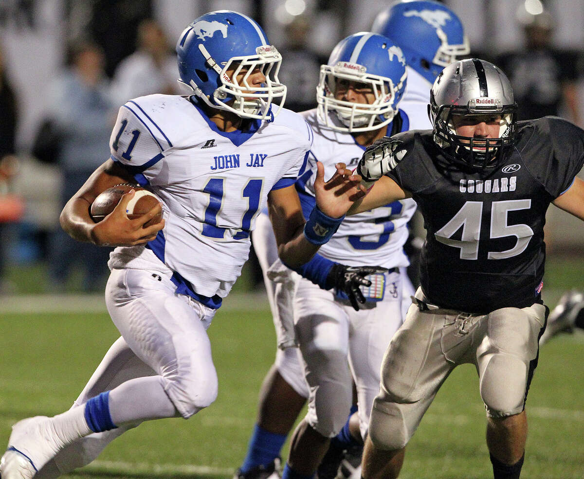 Mustang quarterback Moses Reynolds sprints around the right side with Zach Wood in pursuit as Jay plays Clark at Farris Stadium on October 17, 2013.