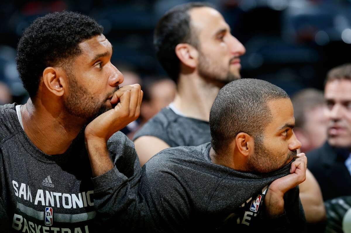 Tim Duncan #21 and Tony Parker #9 of the San Antonio Spurs watch in the final seconds during the game against the Atlanta Hawks at Philips Arena on October 17, 2013 in Atlanta, Georgia.