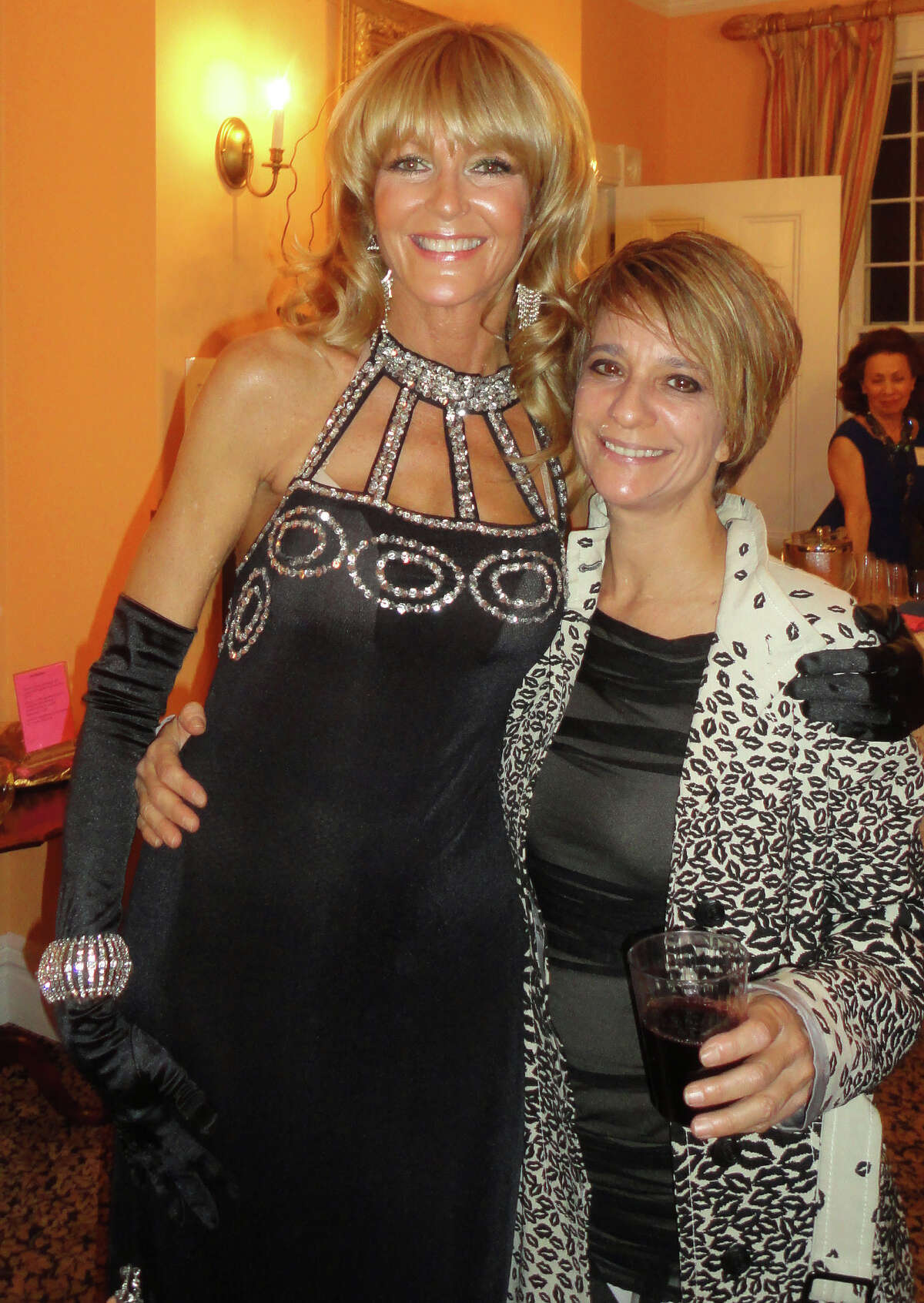 Westport artist Liz Beeby wears a black vintage gown with silver sequins trim Friday as she poses at the Westport Woman's Club with Paula Gallo of Westport, a recipient of a Westport Woman's Club scholarship. Proceeds of the fashion show will go to the club's scholarship program.