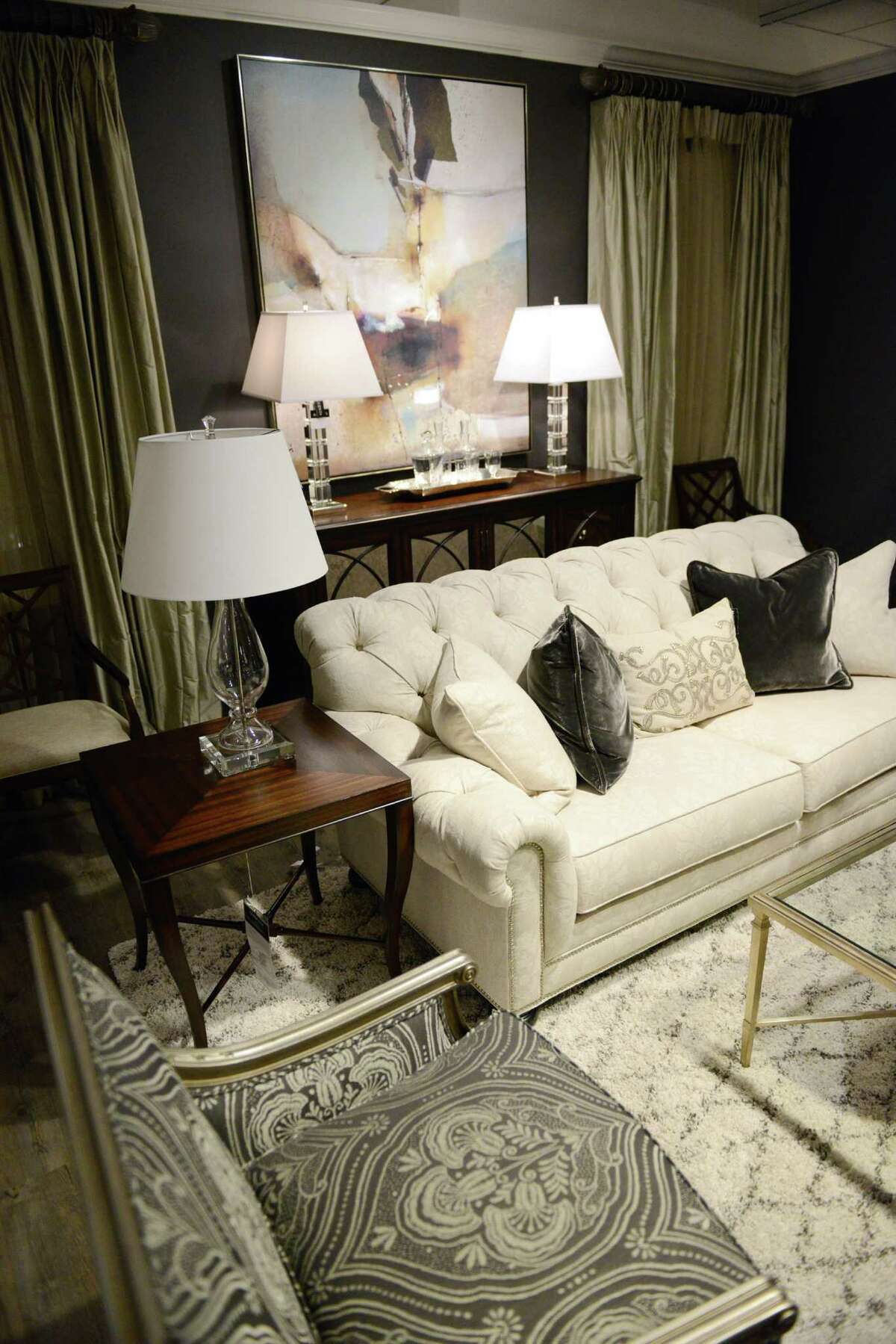This living room setup combines a contemporary artwork and modern lamps with a traditional button-tufted sofa and contemporary fabric on a traditional chair at the unveiling of Ethan Allen's "New Eclecticism" at the Ethan Allen Design Center in Danbury, Conn. on Thursday, Oct. 17, 2013. The New Eclecticism combines modern with traditional interior design qualities, including a variety of colors and textures in the design.
