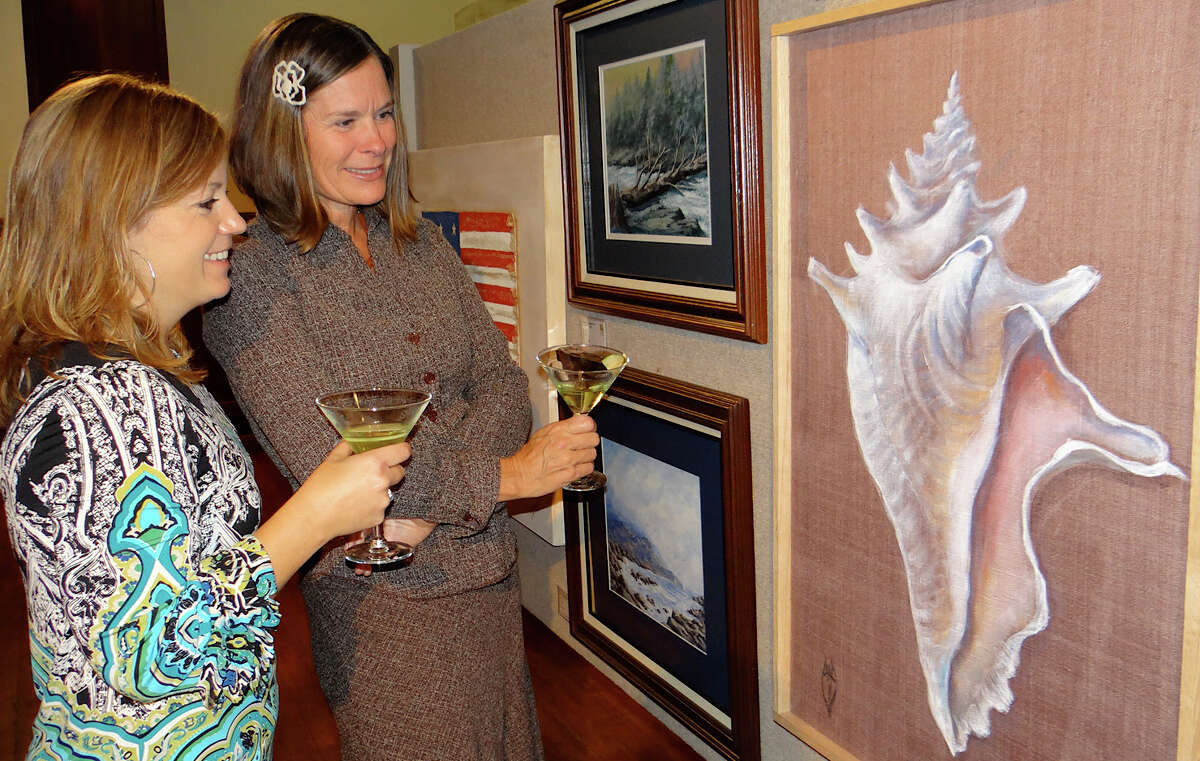 Southport residents Catherine Cunningham and Kellie Panus look at Gay Weathered's "Gift From the Sea" at the preview for the Pequot Library's 16th annual art show Friday.